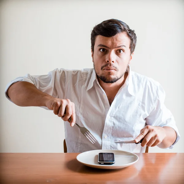 Jovem homem elegante com camisa branca e telefone no prato — Fotografia de Stock