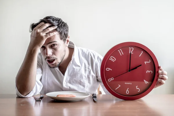 Young stylish man with white shirt holding red clock — Stock Photo, Image