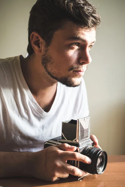 Jonge stijlvolle hipster man met oude camera — Stockfoto