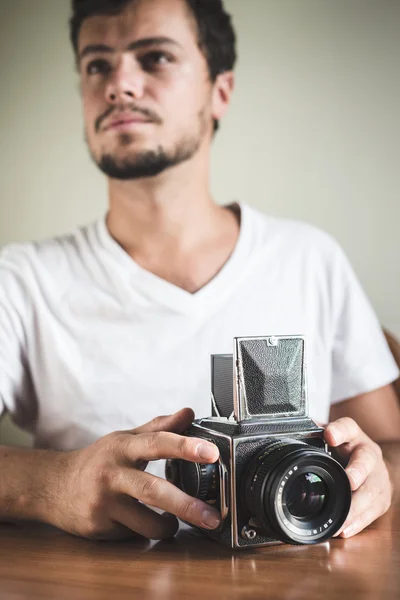 Jonge stijlvolle hipster man met oude camera — Stockfoto
