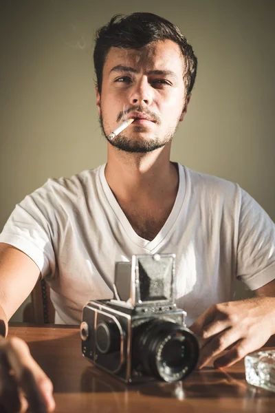 Jonge stijlvolle hipster man met oude camera — Stockfoto