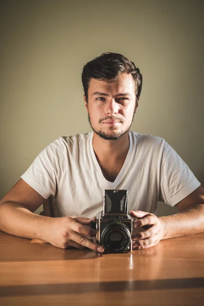 Jonge stijlvolle hipster man met oude camera — Stockfoto