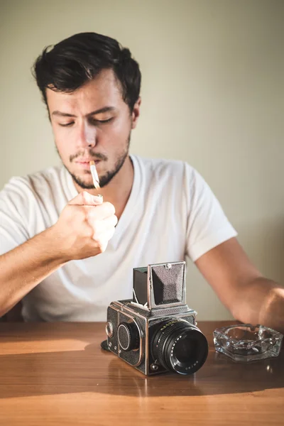 Jonge stijlvolle hipster man met oude camera — Stockfoto