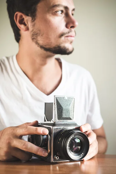 Joven hombre hipster con estilo con cámara vieja — Foto de Stock