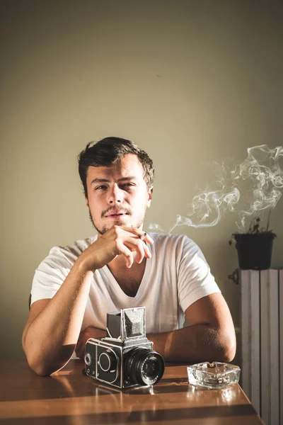 Joven hombre hipster con estilo con cámara vieja — Foto de Stock