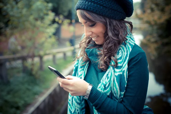 Piękna kobieta z golfem na telefon w mieście — Zdjęcie stockowe