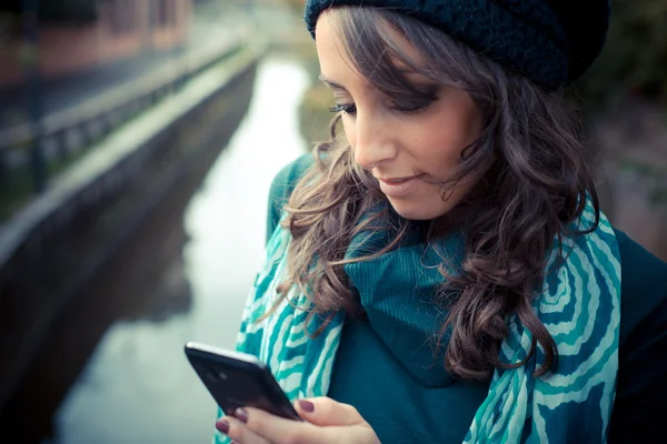 Piękna kobieta z golfem na telefon w mieście — Zdjęcie stockowe