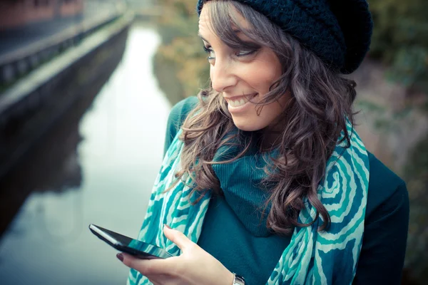 Bella mujer con cuello de tortuga en el teléfono en la ciudad — Stockfoto