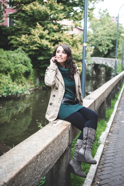 Belle femme avec col roulé au téléphone dans la ville — Photo