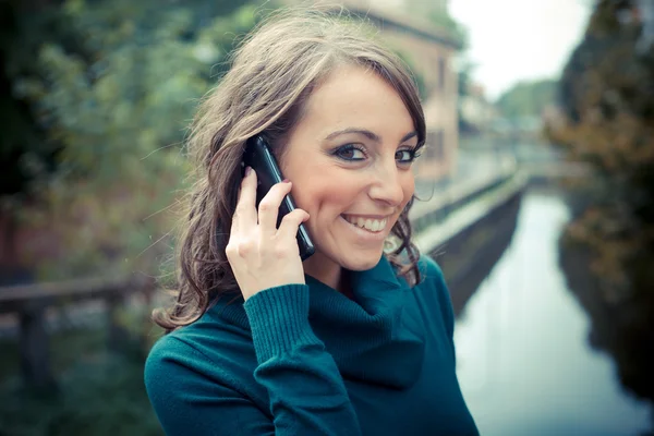 Hermosa mujer con cuello alto en el teléfono en la ciudad — Foto de Stock