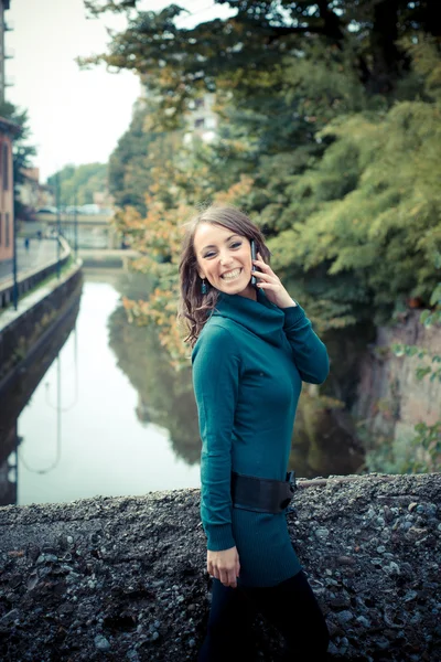 Schöne Frau mit Rollkragen am Telefon in der Stadt — Stockfoto