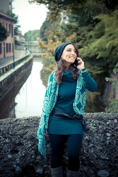 Bella donna con dolcevita al telefono in città — Foto Stock