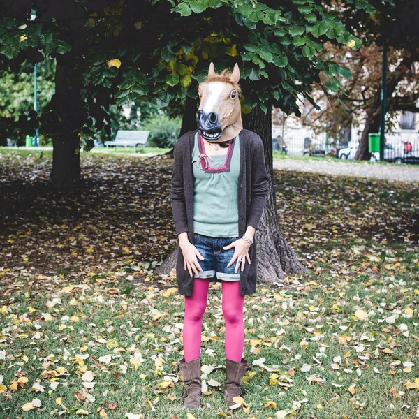 Häst mask kvinna i parken — Stockfoto