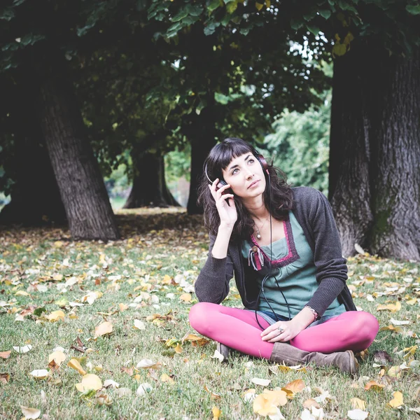 Jonge mooie vrouw luisteren naar muziek herfst — Stockfoto