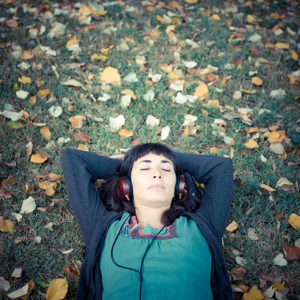 Молодая красивая женщина слушает музыку осенью — стоковое фото