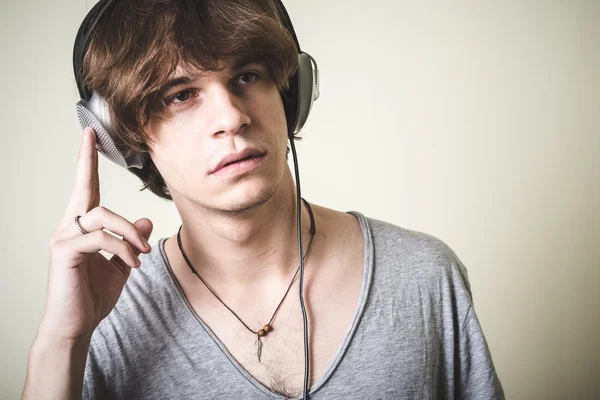 Stylish young blonde hipster man listening to music — Stock fotografie