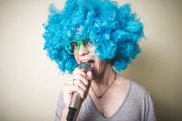 Cara engraçado com peruca azul cantando — Fotografia de Stock