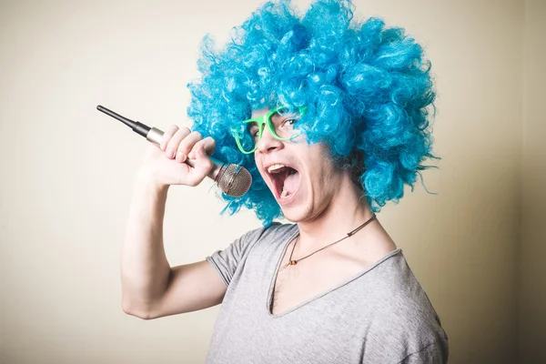 Cara engraçado com peruca azul cantando — Fotografia de Stock