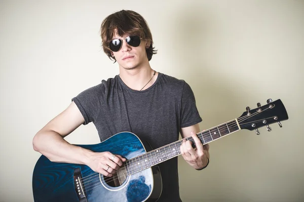 Elegante joven rubia hipster hombre tocando la guitarra —  Fotos de Stock