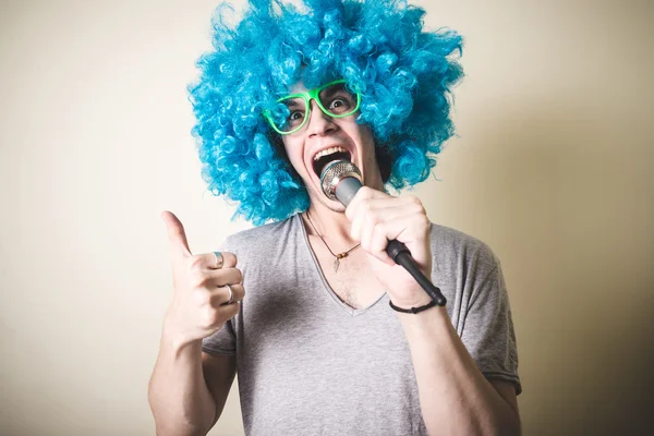 Cara engraçado com peruca azul cantando — Fotografia de Stock