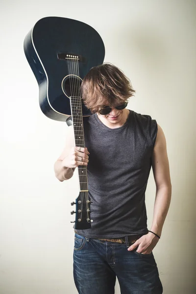 Stilvoller junger blonder Hipster-Mann, der Gitarre spielt — Stockfoto
