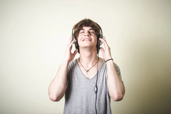 Stylish young blonde hipster man listening to music — ストック写真