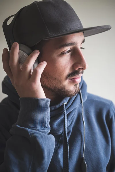 Joven hombre con estilo escuchando música — Foto de Stock