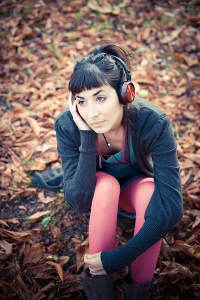 Vacker ung kvinna som lyssnar på musik — Stockfoto