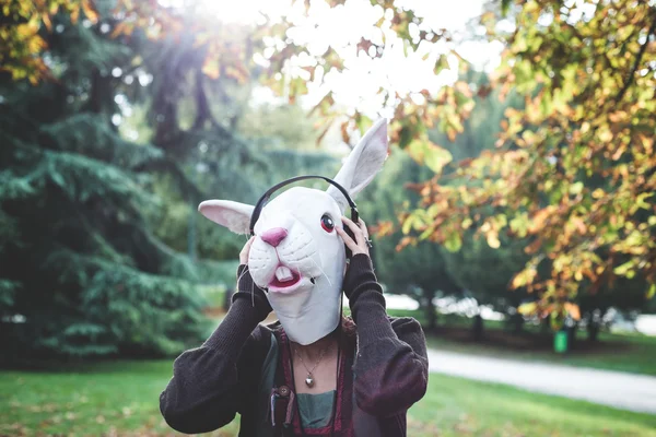 Conejo máscara mujer escuchando música — Foto de Stock