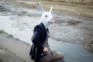 rabbit mask man in a desolate landscape clipart