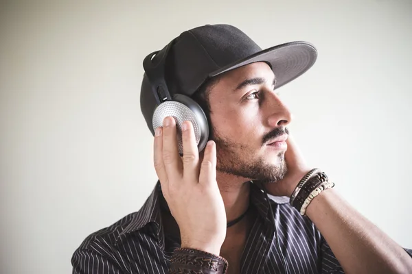 Joven hombre con estilo escuchando música — Foto de Stock