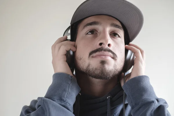 Joven hombre con estilo escuchando música — Foto de Stock