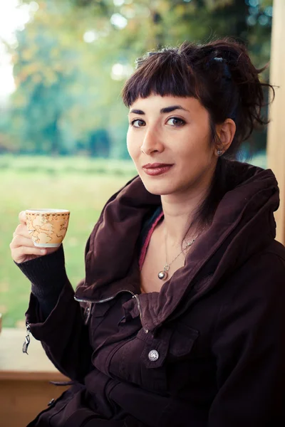 Krásná mladá žena pije kávu — Stock fotografie