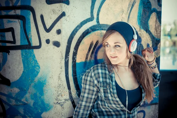 Beautiful young blonde hipster woman listening music — Stock Photo, Image