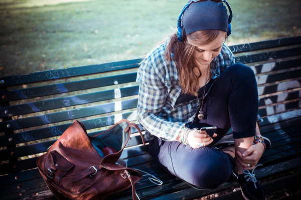 Beautiful young blonde hipster woman listening music — Stock Photo, Image