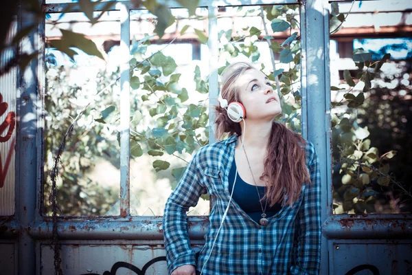 Beautiful young blonde hipster woman listening music — Stock Photo, Image