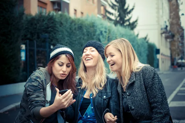 Три подруги женщины по телефону — стоковое фото