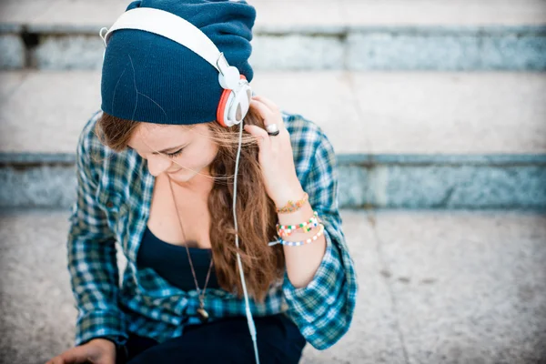 Schöne junge blonde Hipsterfrau, die Musik hört — Stockfoto