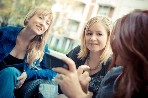 Drie vrienden vrouw aan de bar met behulp van telefoon — Stockfoto