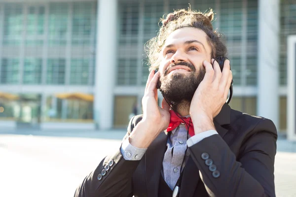 Stylish elegant dreadlocks businessman listening music — Stock Photo, Image