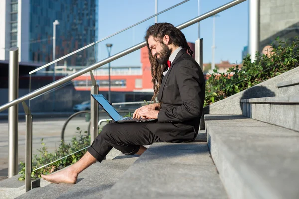 Snygg elegant dreadlocks affärsman använder bärbar dator — Stockfoto