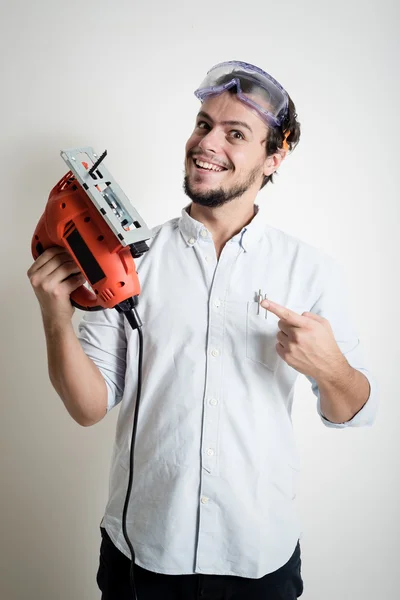 Joven bricolaje trabajando con sierra eléctrica — Foto de Stock