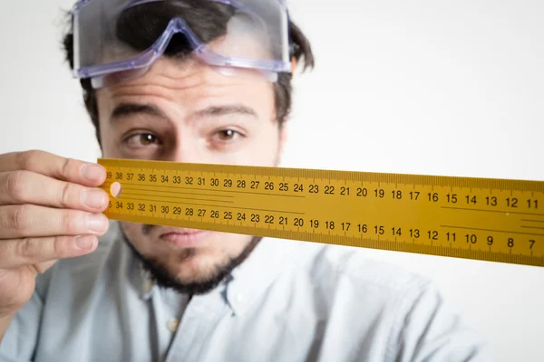Bricolagem jovem trabalhando medição com medidor — Fotografia de Stock
