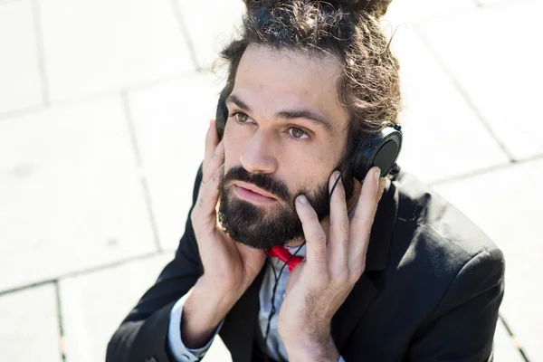 Stylish elegant dreadlocks businessman listening to music — Stock Photo, Image