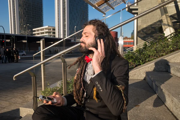 Élégant dreadlocks élégant homme d'affaires écoutant de la musique — Photo