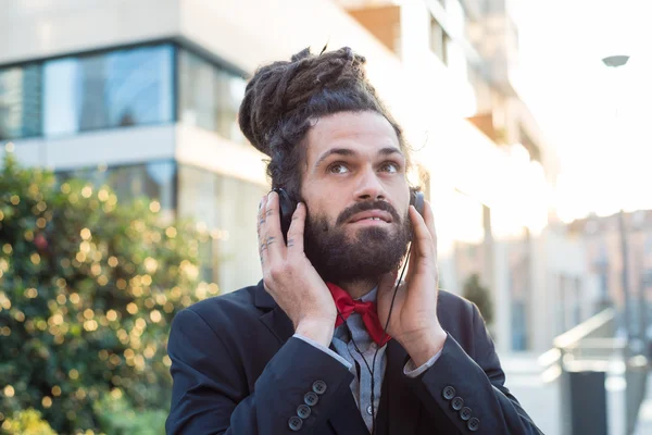 Élégant dreadlocks élégant homme d'affaires écoutant de la musique — Photo