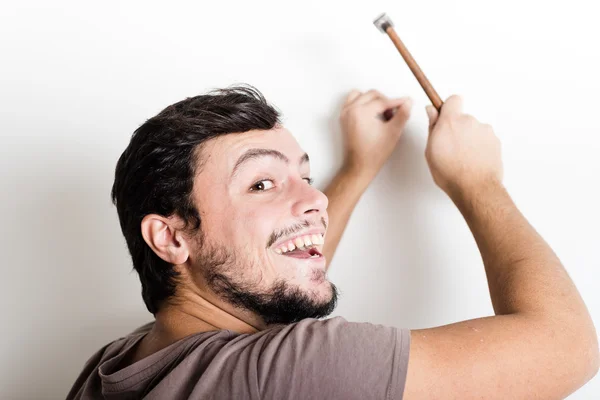 Joven hombre bricolaje martilleo clavo pared — Foto de Stock