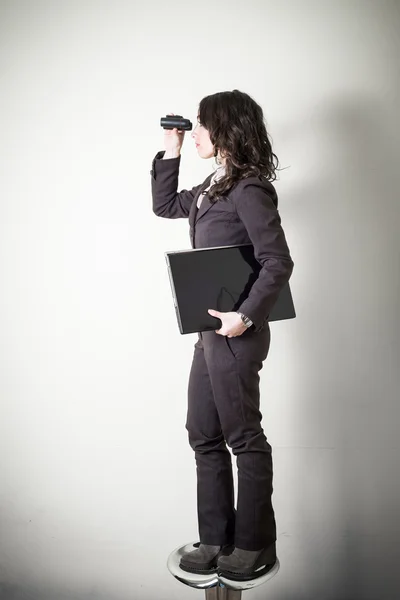 Beautiful young businesswoman with binocular — Stock Photo, Image