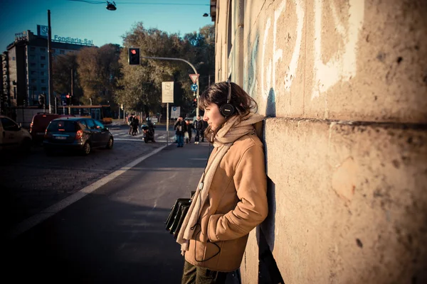 Krásná mladá žena poslechu hudby sluchátka — Stock fotografie