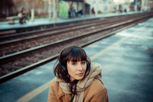 Wanita muda yang cantik mendengarkan headphone musik — Stok Foto